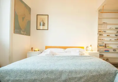a white bedroom with a bed with a blue comforter at Vicino alla Basilica di Santa Maria Maggiore in Rome