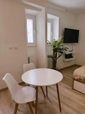 a white living room with a table and chairs at Vacanze Romane House in Rome
