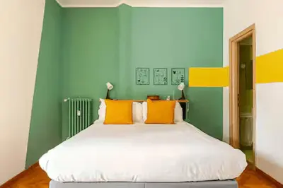 a bedroom with a large bed with yellow and green walls at Casa Bella in Rome