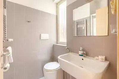 a bathroom with a sink and a toilet and a mirror at Casa Bella in Rome