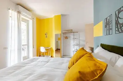 a bedroom with a white bed with a yellow pillow at Casa Bella in Rome