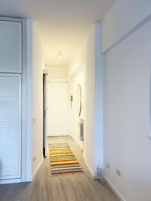a hallway with a door and a rug on the floor at Domus Lucis Rome in Rome