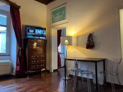 a living room with a dining table and a television at The Charm of Trastevere in Rome