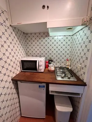 a kitchen counter with a microwave and a stove at The Charm of Trastevere in Rome