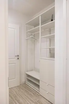 a white closet with white shelves and a door at Vatican House Crocifisso 51 in Rome