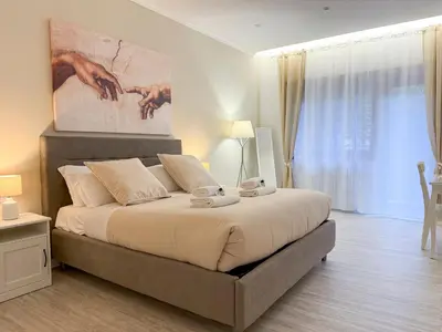 a bedroom with a large bed with a painting on the wall at Vatican House Crocifisso 51 in Rome
