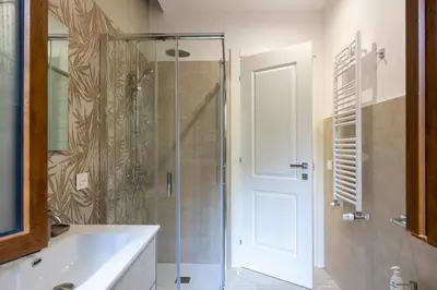 a bathroom with a glass shower and a sink at Vatican House Crocifisso 51 in Rome