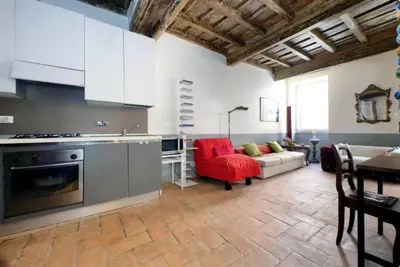a kitchen with a red chair and a couch at Limani - Campo de' Fiori Private Retreat in Rome