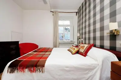 a bedroom with a bed and a red chair at Limani - Campo de' Fiori Private Retreat in Rome