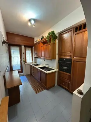 a kitchen with wooden cabinets and a stove top oven at 6 people, 3 parking spot, balconies, Metro B in Rome
