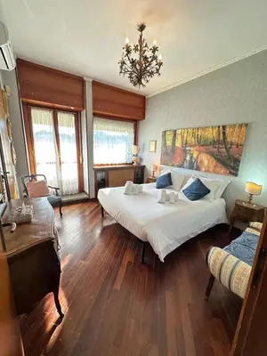 a bedroom with a large bed and a chandelier at 6 people, 3 parking spot, balconies, Metro B in Rome