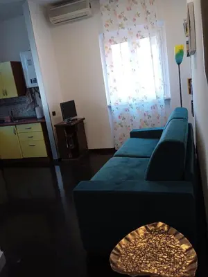 a living room with a blue couch and a window at Monolocale Aurelia in Rome