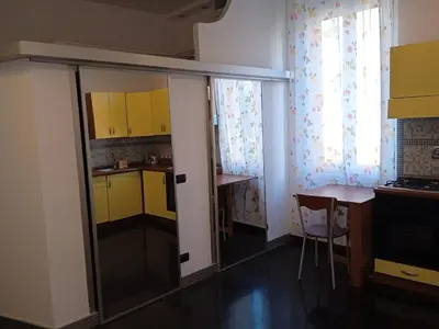 a kitchen with yellow cabinets and a table in a room at Monolocale Aurelia in Rome
