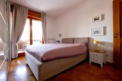 a bedroom with a bed and a large window at Holiday Home Roma in Rome