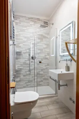 a bathroom with a shower and a toilet and a sink at Holiday Home Roma in Rome