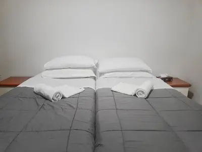 a bed with white blankets and towels on it at Niam House in Rome