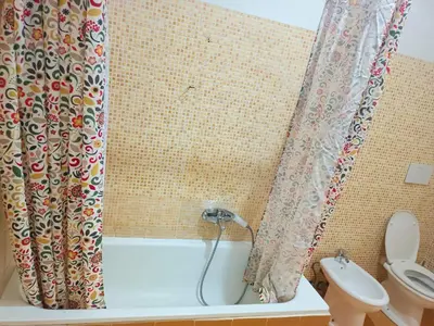 a bathroom with a shower curtain and a toilet at Niam House in Rome