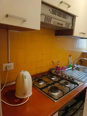 a kitchen with a stove top oven and a sink at Niam House in Rome