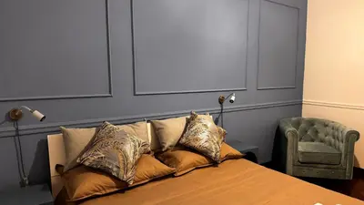 a bedroom with a bed and a green chair at Raffy in Rome in Rome
