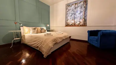 a bedroom with a bed and a blue chair at Raffy in Rome in Rome