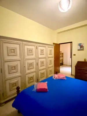 a bedroom with a blue bed with two red pillows at Laterani36 elegante Appartamento 3 Camere, sopra Metro Porta Metronia in Rome