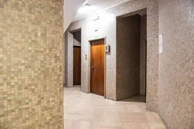an empty hallway with a wooden door and tile walls at Laterani36 elegante Appartamento 3 Camere, sopra Metro Porta Metronia in Rome