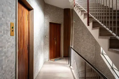a hallway with a staircase and a brown door at Laterani36 elegante Appartamento 3 Camere, sopra Metro Porta Metronia in Rome