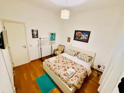 a bedroom with a bed and a chair in it at TURATI ROOMs in Rome