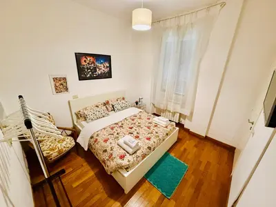 a small bedroom with a bed and a chair at TURATI ROOMs in Rome