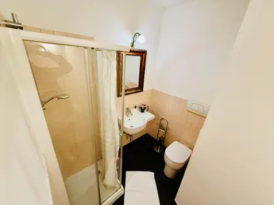 a bathroom with a shower and a toilet and a sink at TURATI ROOMs in Rome