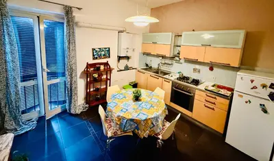 a small kitchen with a table and a refrigerator at TURATI ROOMs in Rome