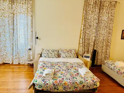 a bedroom with a bed and two windows with curtains at TURATI ROOMs in Rome