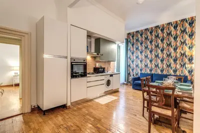 a kitchen and living room with a table and a refrigerator at Fresh House Ludovisi in Rome