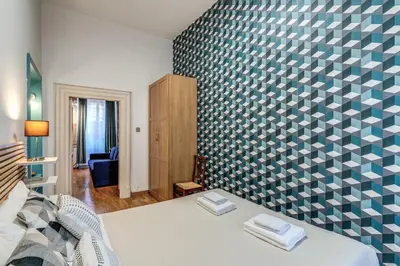 a bedroom with a blue and white patterned wall at Fresh House Ludovisi in Rome
