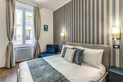 a bedroom with a bed and a blue chair at Casa Bixio Fantastico appartamento nel cuore di Roma in Rome