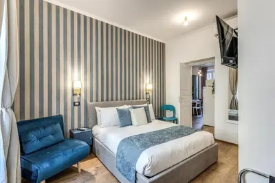 a bedroom with a bed and a blue chair at Casa Bixio Fantastico appartamento nel cuore di Roma in Rome