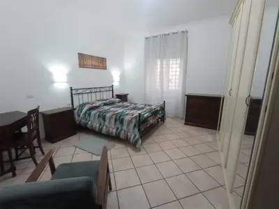 a bedroom with a bed and a table and chairs at Casa di Roberto - Metro e Servizi a due passi! in Rome