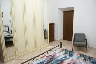 a bedroom with a mirror and a chair and a bed at Casa di Roberto - Metro e Servizi a due passi! in Rome