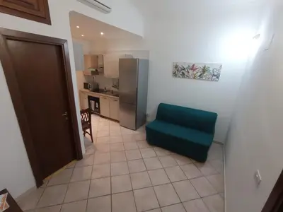 a small kitchen with a green chair in a room at Casa di Roberto - Metro e Servizi a due passi! in Rome
