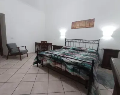 a bedroom with a bed and a chair at Casa di Roberto - Metro e Servizi a due passi! in Rome