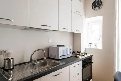 a white kitchen with a sink and a microwave at ST PETER APARTMENT metro at 3 minutes in Rome
