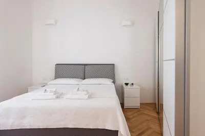 a white bedroom with a large bed with two white towels at ST PETER APARTMENT metro at 3 minutes in Rome