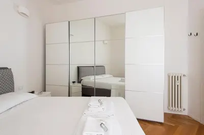 a bedroom with a white bed and a mirror at ST PETER APARTMENT metro at 3 minutes in Rome