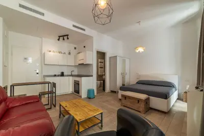 a living room with a bed and a kitchen at GuestHost - Ostiense Modern ApartamentS in Rome