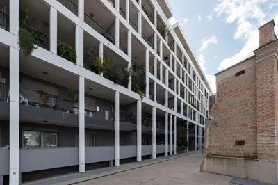 an apartment building with white columns and a brick wall at GuestHost - Ostiense Modern ApartamentS in Rome