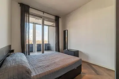 a bedroom with a bed and a large window at GuestHost - Ostiense Modern ApartamentS in Rome