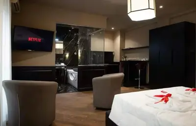 a room with a table and chairs and a television at Elegante loft nel cuore di Roma in Rome
