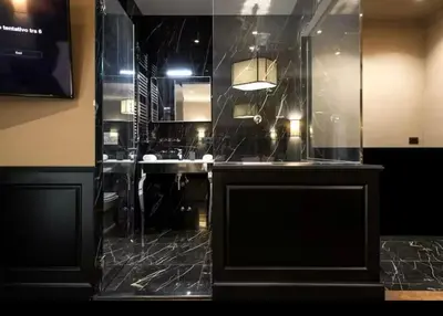a bathroom with a glass wall with a sink at Elegante loft nel cuore di Roma in Rome