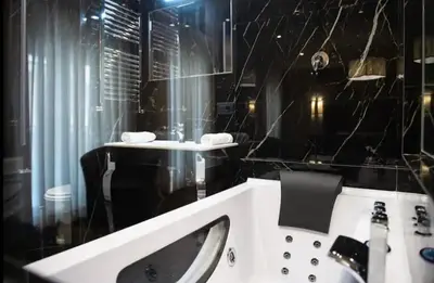 a black and white bathroom with a sink and a mirror at Elegante loft nel cuore di Roma in Rome