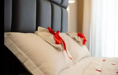 two white pillows with red bows on a bed at Elegante loft nel cuore di Roma in Rome